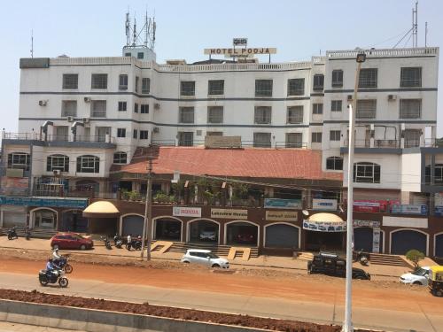 a building with a motorcycle parked in front of it at Hotel Pooja International in Dāvangere