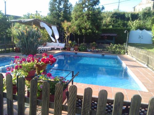 a swimming pool with flowers in a yard at El Atico de Villalmar in Tui