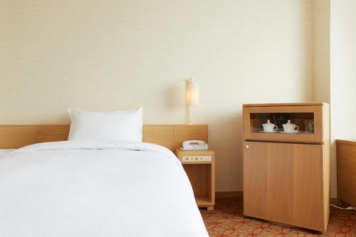 a hotel room with a bed and a tv at Keio Plaza Hotel Sapporo in Sapporo