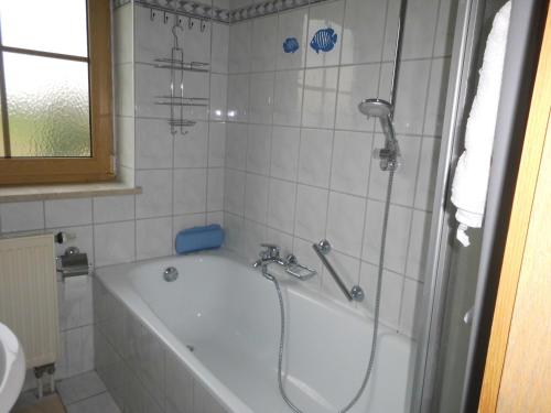 a bath tub in a bathroom with a shower at Schwaigerhof in Grassau