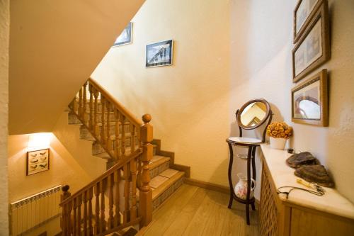 a hallway with a staircase with a mirror on a counter at Hostal Rural Salazar in Oronz