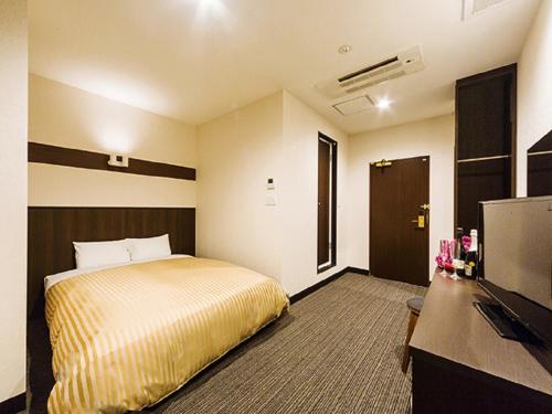 a hotel room with a bed and a flat screen tv at Hotel CASVI Tenjin in Fukuoka