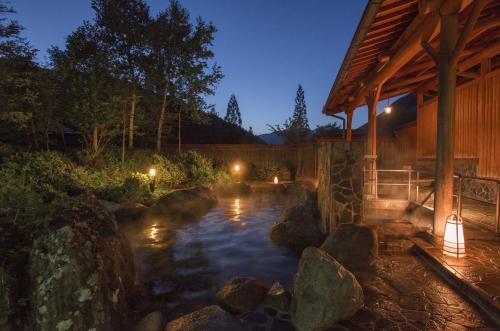 a pond in a backyard with a house at Nakamurakan in Takayama