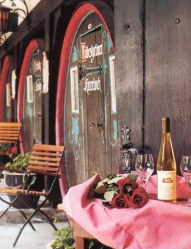 a table with a bottle of wine next to a door at Hotel Lindenwirt in Rüdesheim am Rhein