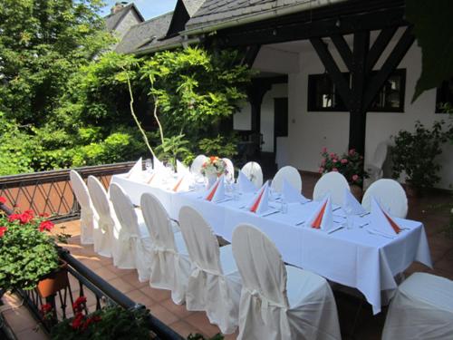 a group of white tables and white chairs at Hotel Lindenwirt in Rüdesheim am Rhein
