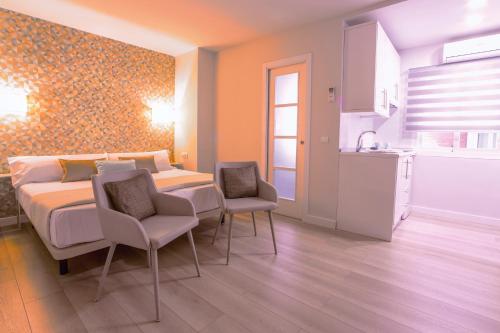 1 dormitorio con 1 cama y 2 sillas y cocina en Apartamento Malaga Beach, en Málaga