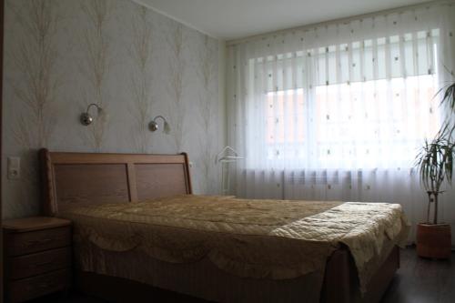 a bedroom with a bed and a large window at Family Apartment Nida in Nida