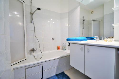 ニーウポールトにあるResidentie Scorpio B1の白いバスルーム(シャワー、バスタブ、シンク付)