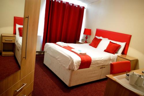 a bedroom with a bed and a red curtain at Hotel Express Newcastle Gateshead in Newcastle upon Tyne