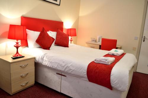 a bedroom with a large bed and two red chairs at Hotel Express Newcastle Gateshead in Newcastle upon Tyne