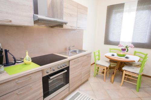 a kitchen with a sink and a table with chairs at Apartment Kampel in Koper