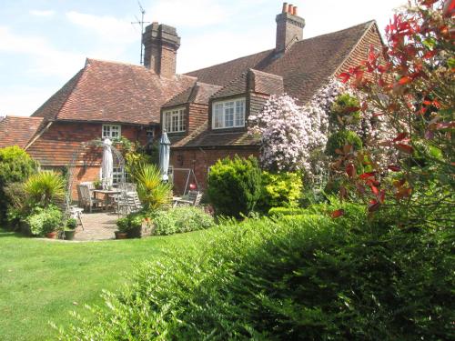 an old house with a garden in front of it at Clayton Wickham Farmhouse in Hurstpierpoint