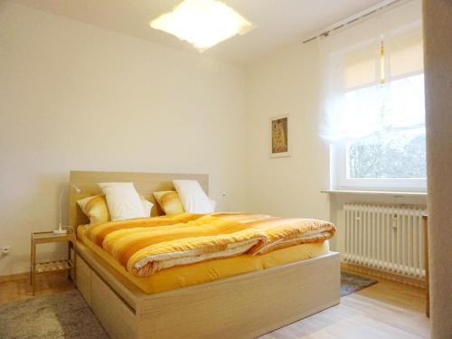 a bedroom with a bed with yellow blankets and a window at Gästehaus Elena in Kassel