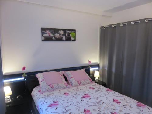 a bedroom with a bed with pink sheets and pink pillows at Gîte du Vieux Marché in Le Havre