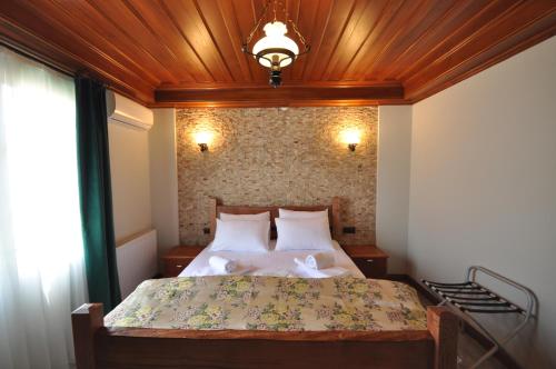 a bedroom with a bed with a wooden ceiling at Cunda Svila Otel - Adult Only in Ayvalık