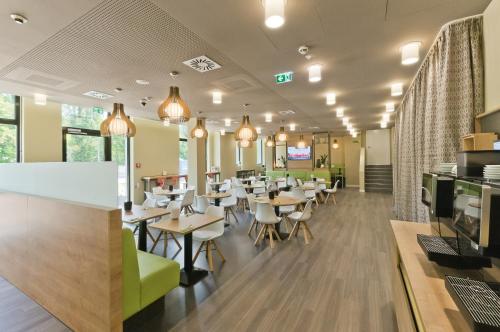 a restaurant with tables and chairs in a cafeteria at Super 8 Freiburg in Freiburg im Breisgau