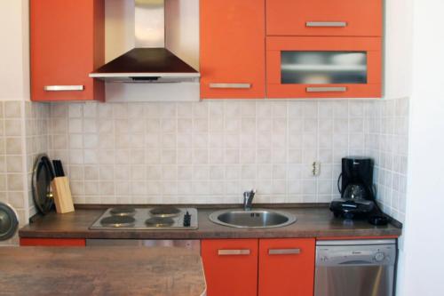 eine Küche mit orangefarbenen Schränken und einem Waschbecken in der Unterkunft Apartment San Elena in Rovinj