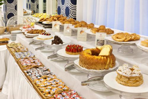 une table remplie de différents types de pâtisseries et de desserts dans l'établissement Hotel Continental, à Sorrente