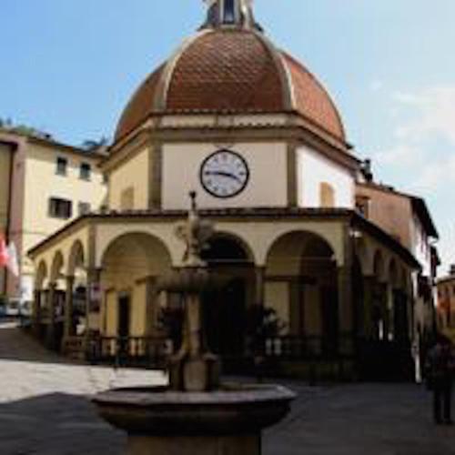 a building with a clock tower with a fountain in front at La Terrazza in Poppi