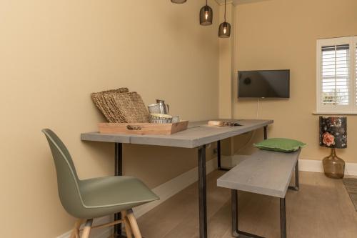 a room with a desk and a chair and a television at De Herberg Appartementen in Renesse