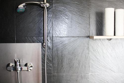 een douche met een douchekop in de badkamer bij Appartamenti Mori in Belluno