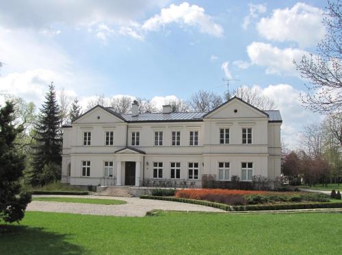 a large white house with a lawn in front at Biały Pałac Palczew in Palczew