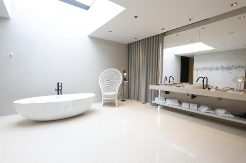 a bathroom with a large white tub and a sink at Montebelo Vista Alegre Ílhavo Hotel in Ílhavo