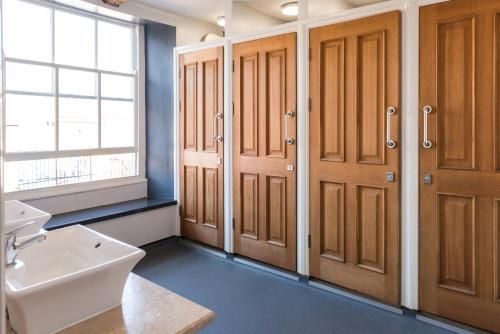 a bathroom with wooden cabinets and a sink and a toilet at The Full Moon Backpackers in Bristol
