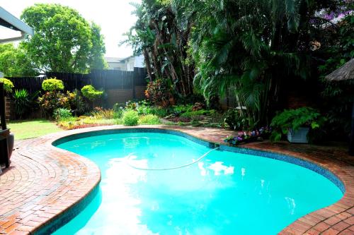 a swimming pool with a hose in a yard at Oliveroom Self Catering and B&B in Durban