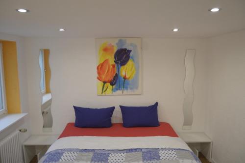 a bedroom with a bed with blue pillows and a painting at Yeti Lux - Art Appartement in Garmisch-Partenkirchen