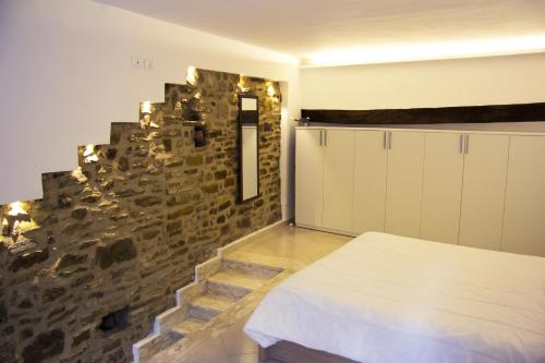 Habitación con cama y pared de piedra. en U' Vascio - Centro Storico, en Castellabate