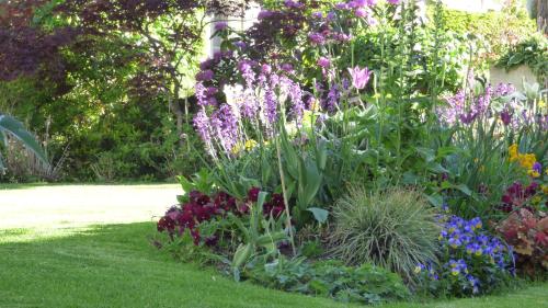 a garden with colorful flowers in a yard at Hôtel La Tonnellerie in Beaugency