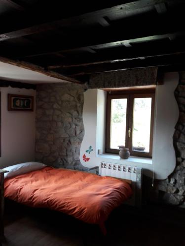 a bedroom with a bed and a window at El Cuetu in Posada