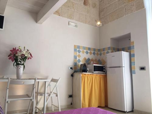 una cucina con frigorifero e tavolo con sedie di Cantaluna B&B a Polignano a Mare