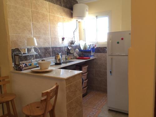 a kitchen with a white refrigerator and a table at Pyramids Overlook Inn in Cairo