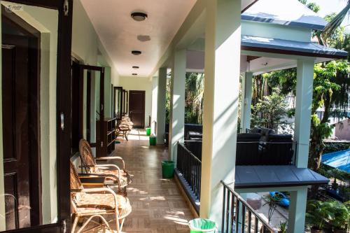 un portico di una casa con sedie e tavoli di Yeti Guest House a Pokhara