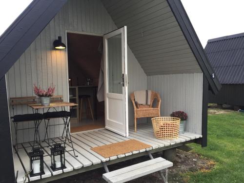 an open door of a house with a chair on a porch at Dancamps Nordsø Water Park in Hvide Sande
