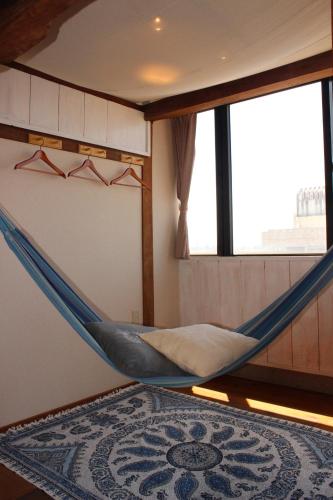 a hammock in a room with a window at guest house Holoholo Ishigakijima in Ishigaki Island