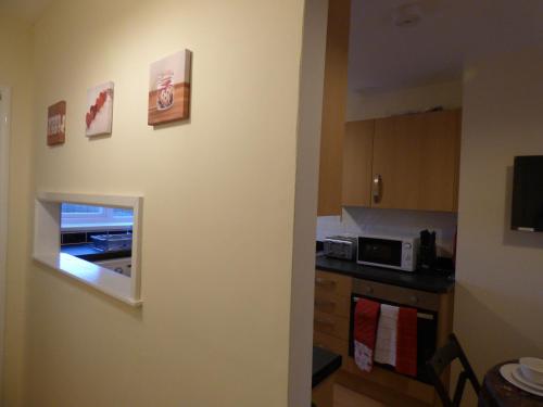 a kitchen with a wall with some pictures on it at Birdholme House in Chesterfield