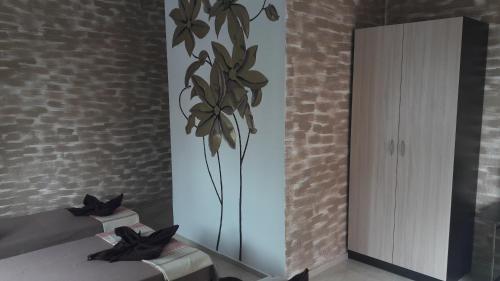 a bedroom with a mirror and a flower on the wall at Dracena Guesthouse in Ravda
