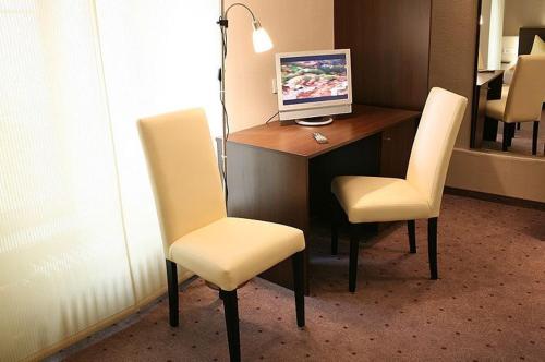 a desk with two chairs and a computer on it at Hotel Garni Krone in Radolfzell am Bodensee