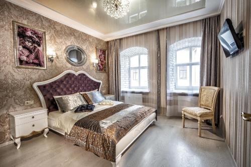 a bedroom with a large bed and a chair at 2 - bedroom Apartments Galicia Lviv in Lviv