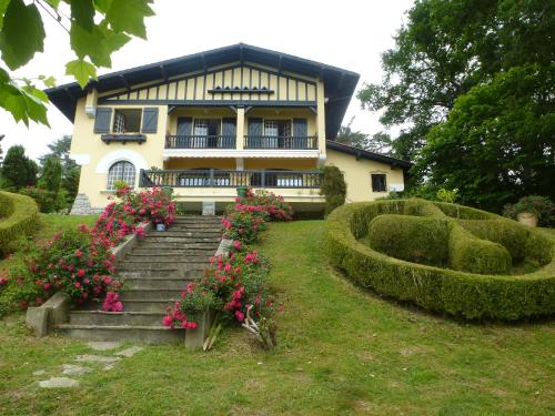 une maison avec des fleurs et des escaliers en face de celle-ci dans l'établissement Villa La Croix Basque, à Ciboure