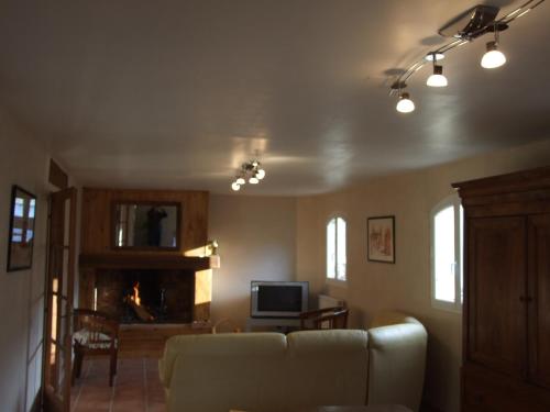a living room with a couch and a tv at La Ferme de Gayri, chalet d'exception avec sauna et jacuzzi à 5 minutes de St-Lary Soulan in Vielle-Aure