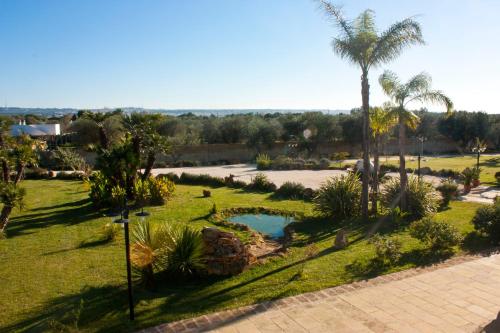 an aerial view of a park with a swimming pool and palm trees at Agriturismo Paradiso in Parabita