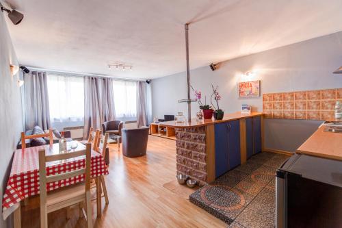 a kitchen and living room with a table and chairs at Apartament MonteCassino in Szczecin