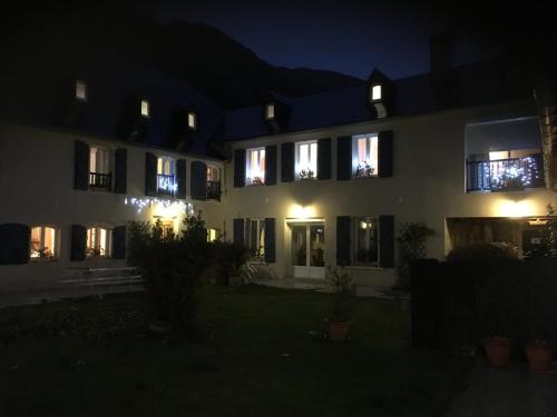 a large white building with lit up windows at night at La Ferme de Gayri, chalet d'exception avec sauna et jacuzzi à 5 minutes de St-Lary Soulan in Vielle-Aure