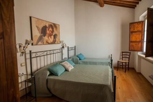 ソヴィチッレにあるCasa Viale dei Cipressiのベッドルーム1室(ベッド2台付)が備わります。壁には絵画が飾られています。