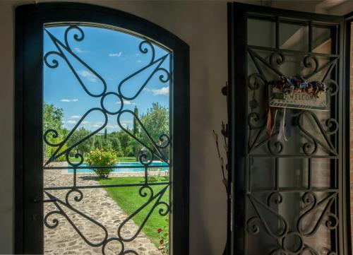 an open door with a view of a yard at Casa Viale dei Cipressi in Sovicille