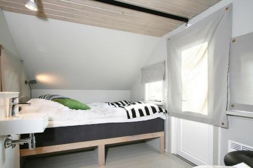 
a bedroom with a white bed and white walls at Dancamps Nordsø Water Park in Hvide Sande
